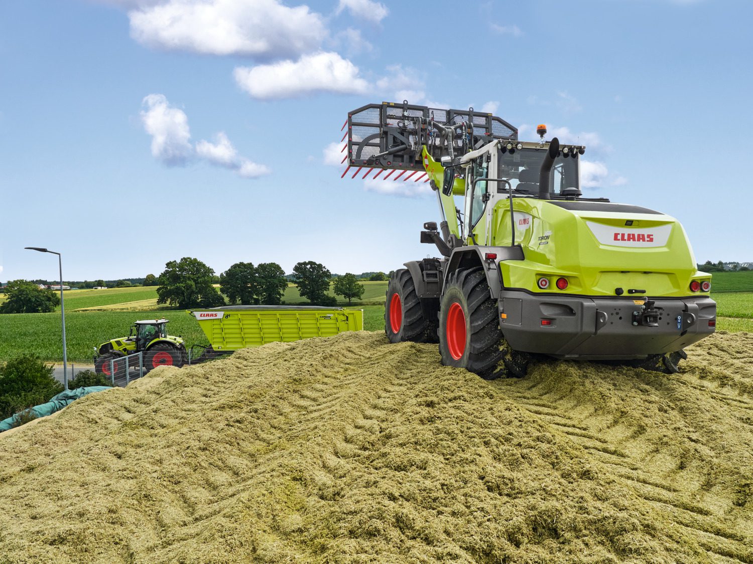 CLAAS TORION on silage with CLAAS Tractor in background